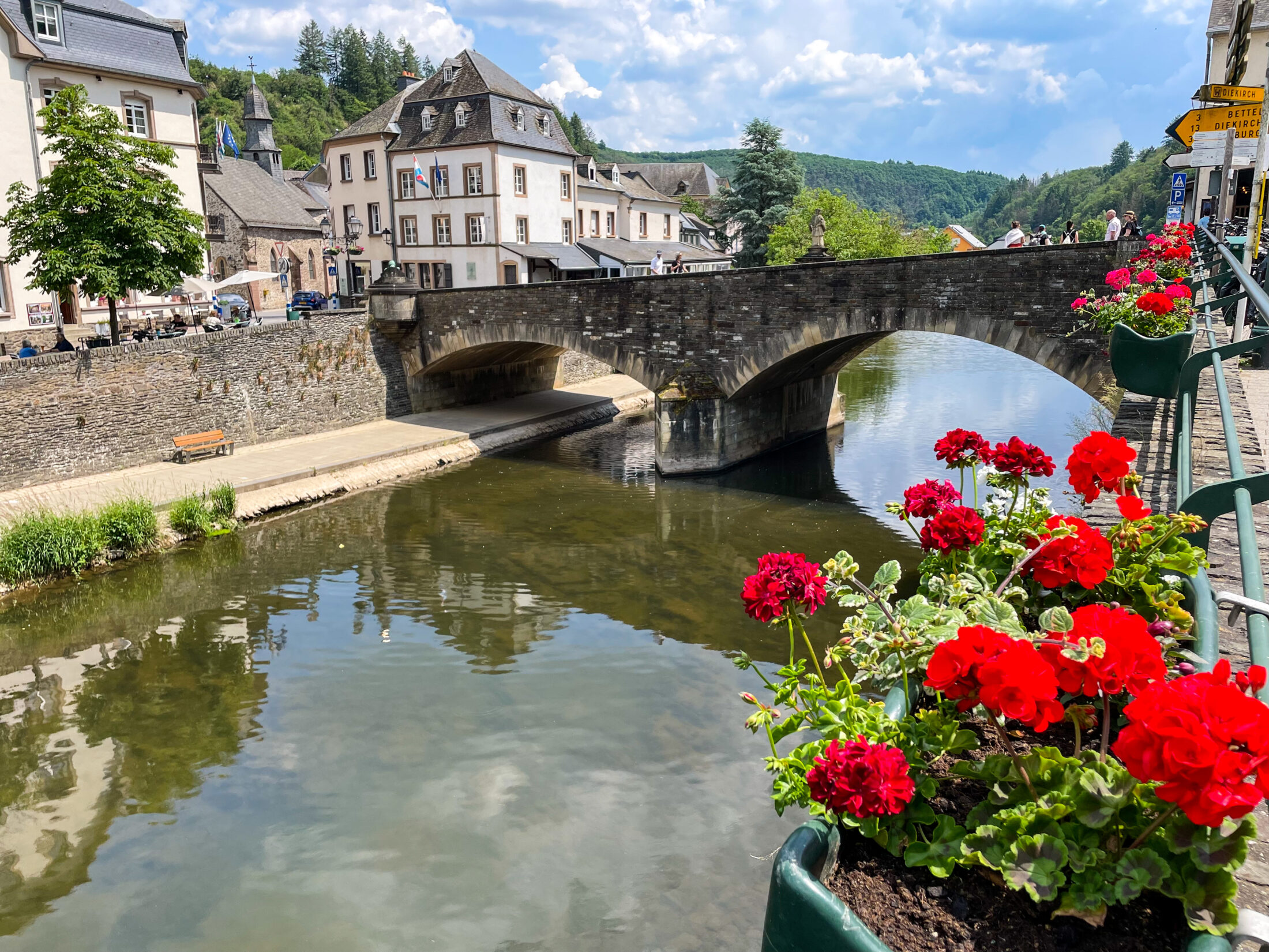 Ein Tag in Vianden Luxemburg Stadtrundgang Sehenswürdigkeiten Highlights Reisetipps: Blumen und die Brücke über den Fluss Our in Vianden